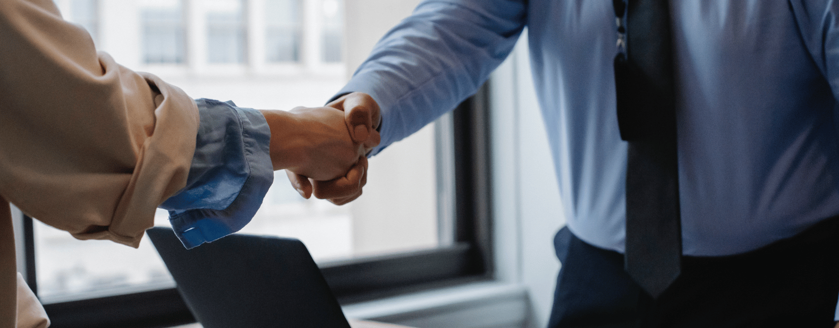 A candidate shaking hands after being placed in a new healthcare role