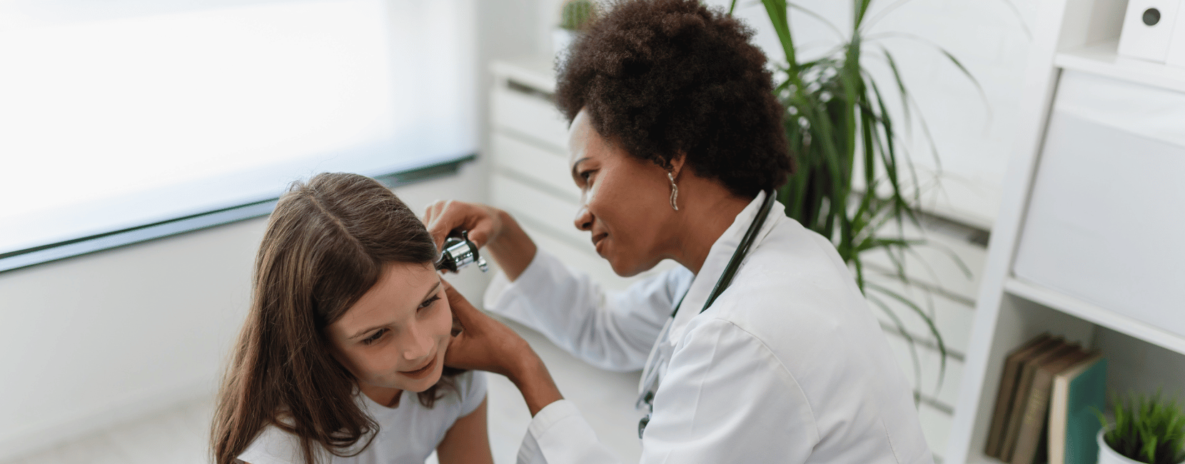 Healthcare technician examining a patient with a diagnostic instrument